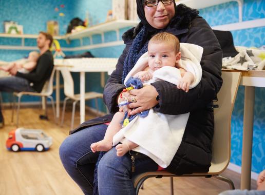 Vrouw met baby op schoot in wachtkamer 