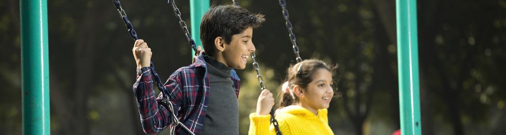 Asielzoekers kinderen spelen buiten op schommel