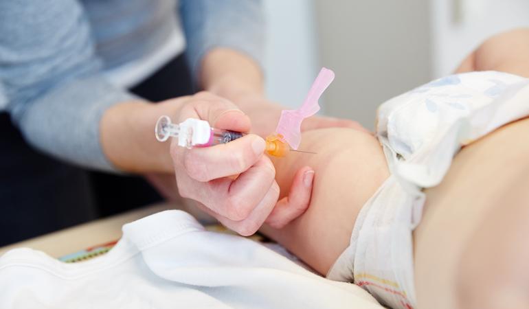 arts geeft vaccinatie in rechter bovenbeen baby