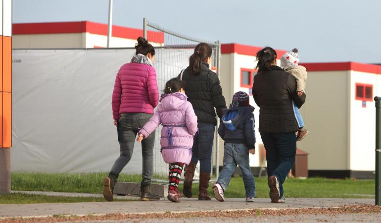 vijf asielzoekers lopen over een pad