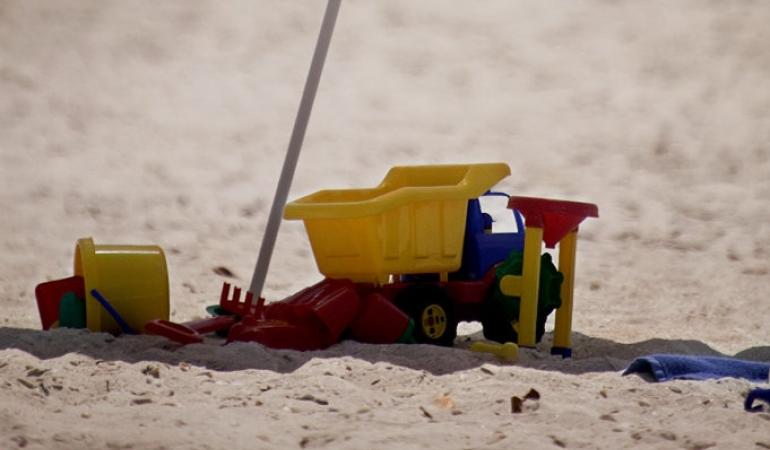 Strand met parasol en kinderspeelgoed