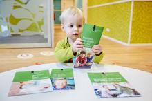 Veel gezocht Jongetje bekijkt leaflets van het Rijksvaccinatieprogramma