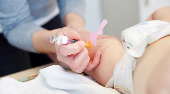 arts geeft vaccinatie in rechter bovenbeen baby