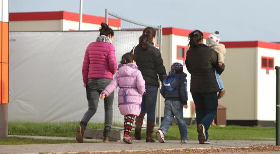 vijf asielzoekers lopen over een pad