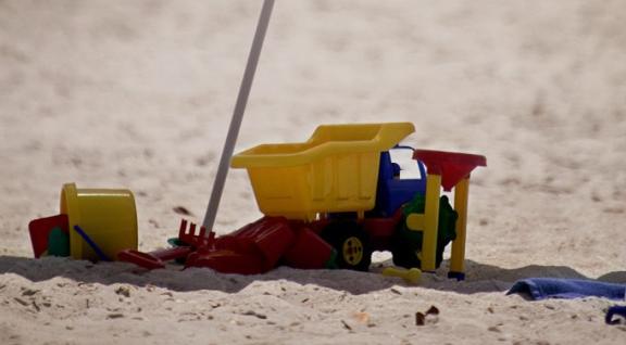 Strand met parasol en kinderspeelgoed