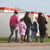 vijf asielzoekers lopen over een pad