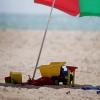 Strand met parasol en kinderspeelgoed